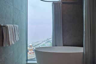 bathroom with bathtub by window at scandic oceanhamnen