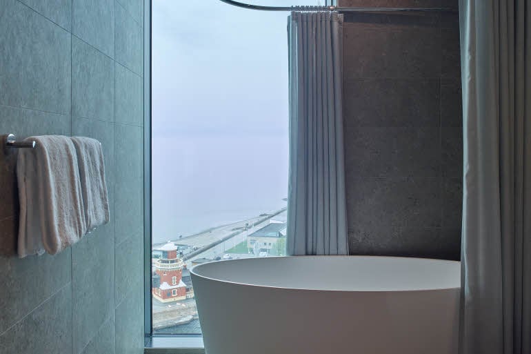 bathroom with bathtub by window at scandic oceanhamnen