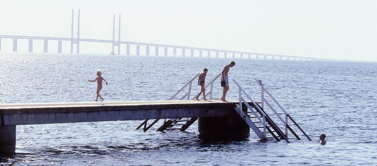 Børn bader ved Amager Strandpark med Øresundsbron i baggrunden